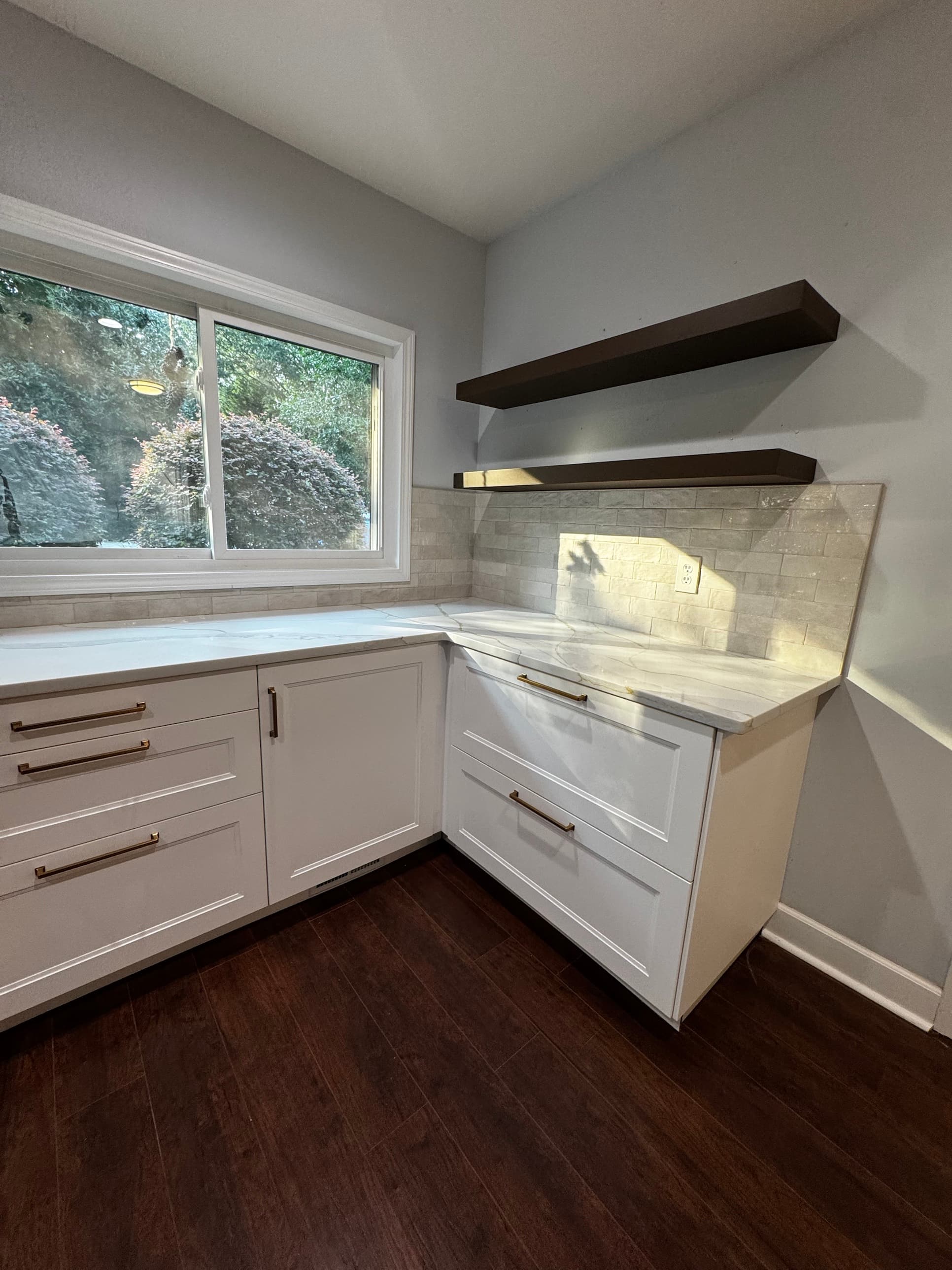 Kitchen corner detail with floating walnut shelves, gold hardware, and marble quartz countertop — Charlotte kitchen renovation by Remodel CLT