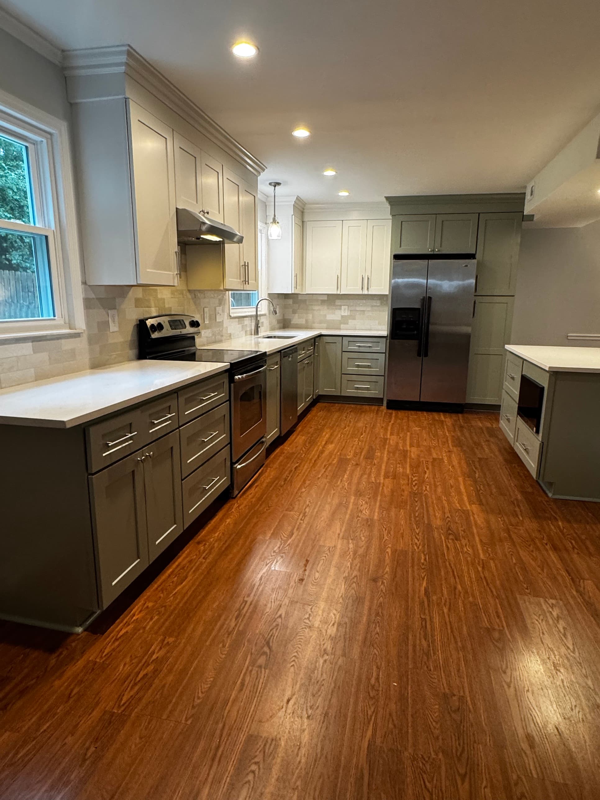 Full kitchen renovation with two-tone shaker cabinets, stainless appliances, and hardwood floors by Remodel CLT in Charlotte, NC