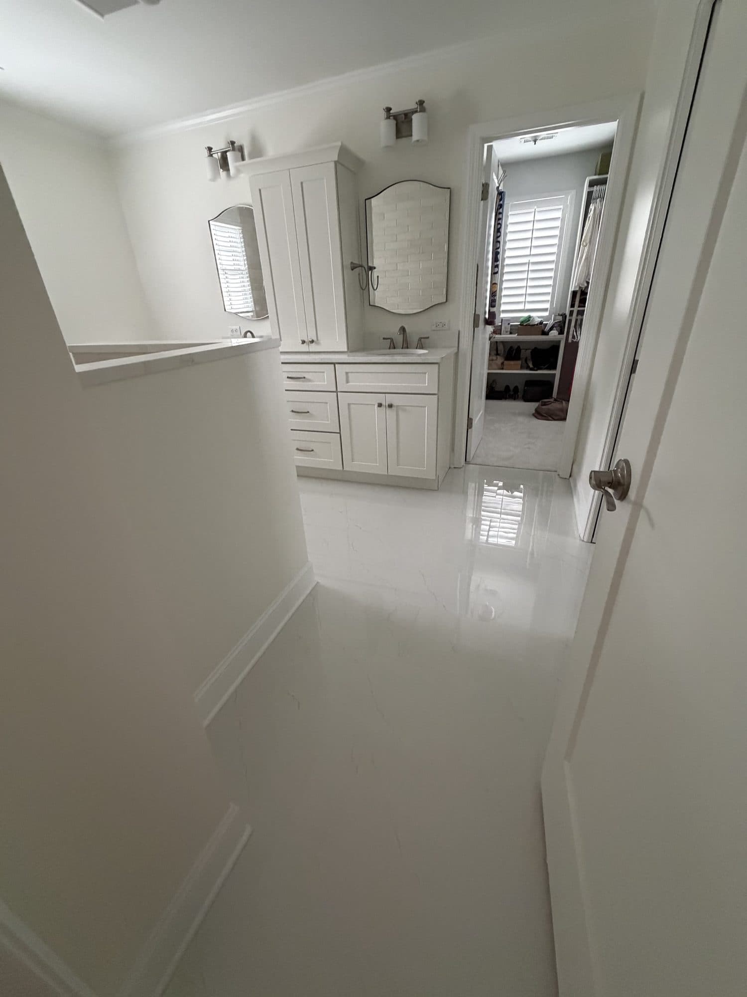 Bathroom remodel with polished white tile floor and white vanity in Charlotte NC