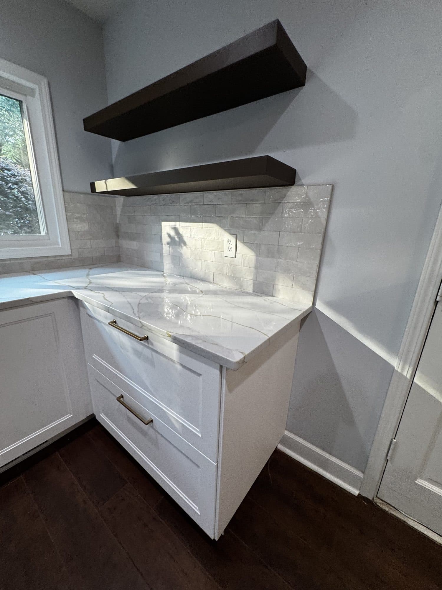 Handmade-look subway tile backsplash with floating shelves and gold-veined quartz countertop in Charlotte NC