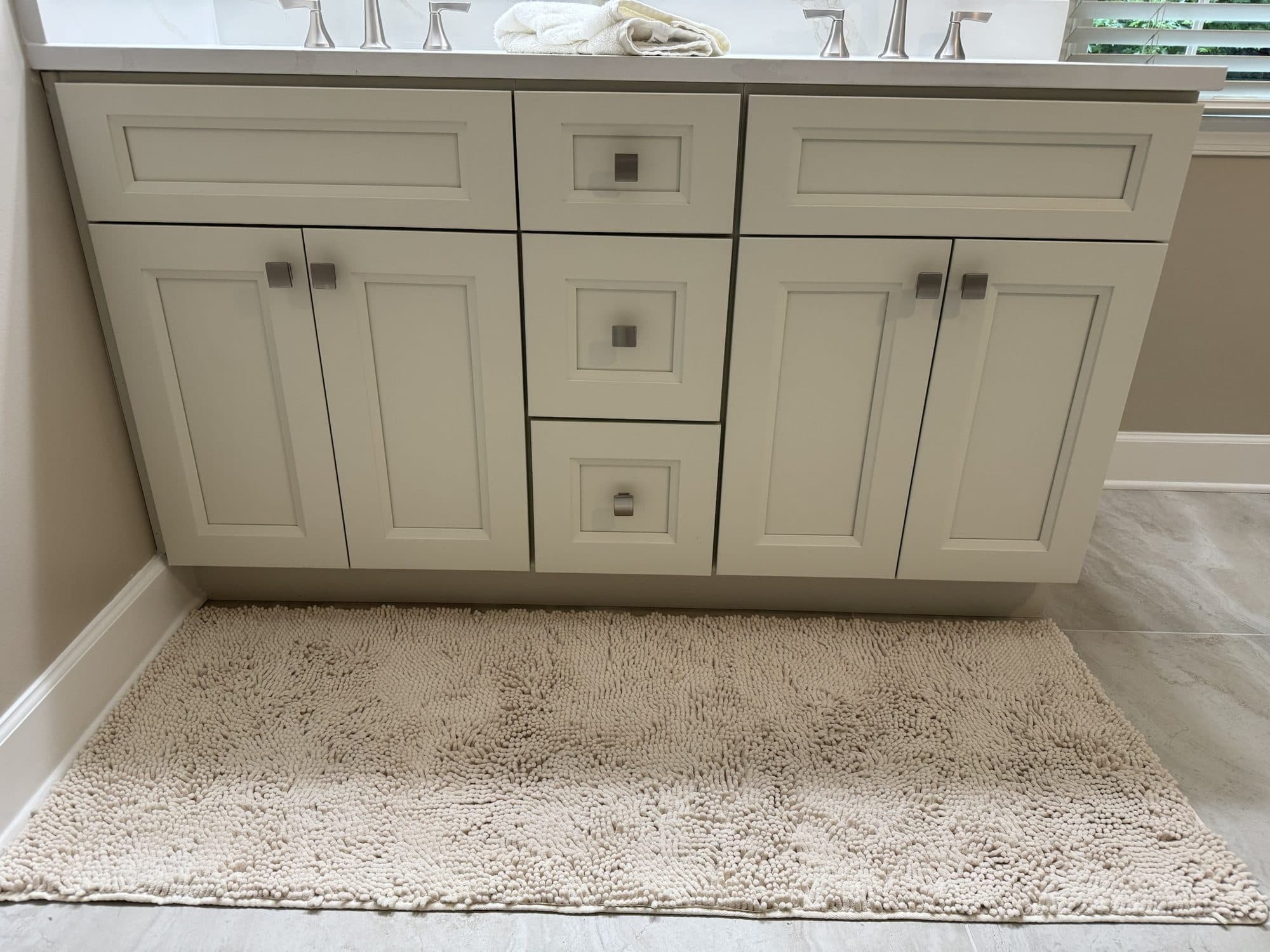 New white shaker double vanity with quartz top and brushed nickel hardware in a Matthews, NC primary bath