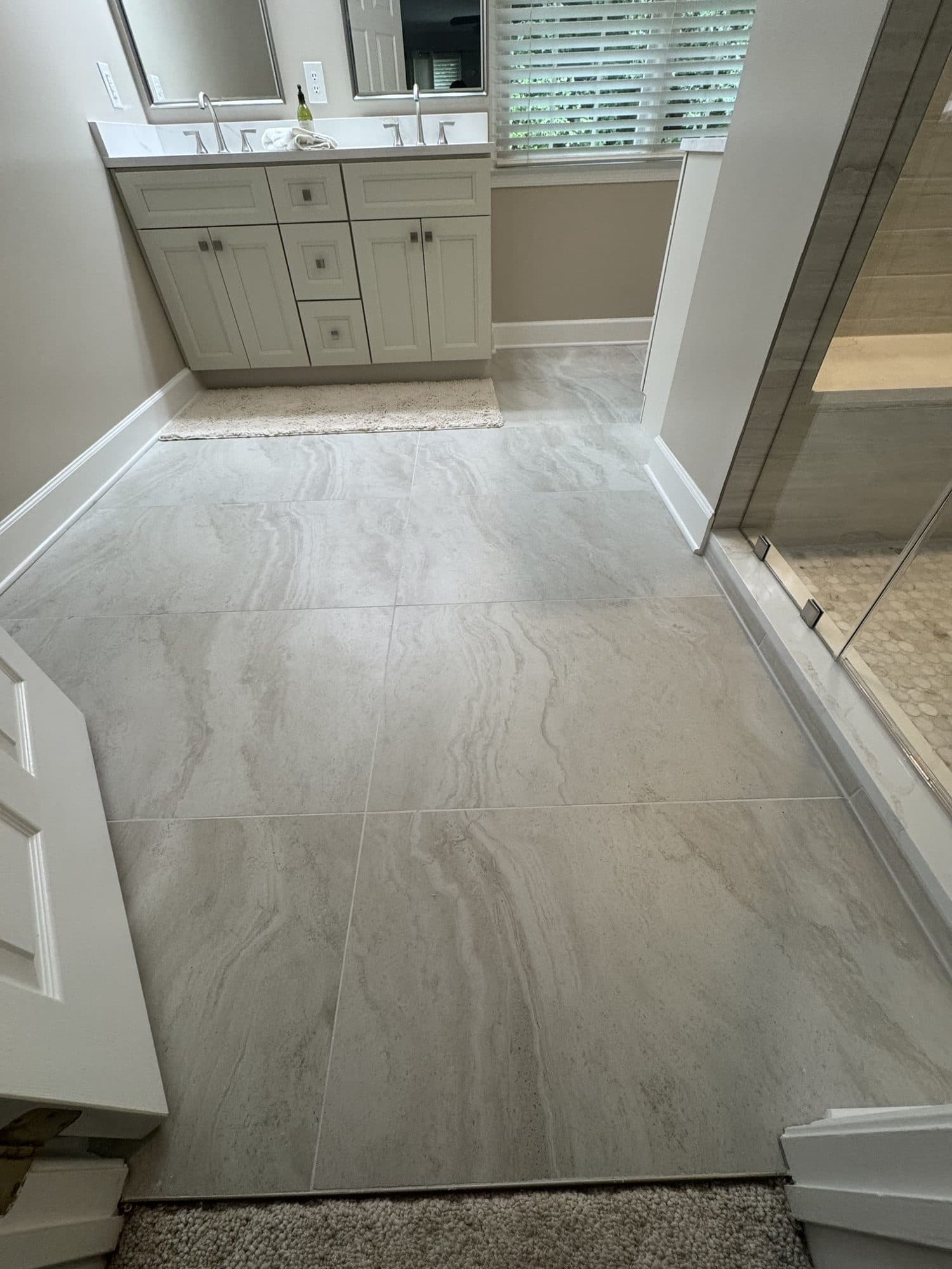 Large-format veined porcelain bathroom floor in a Matthews, NC primary bath remodel