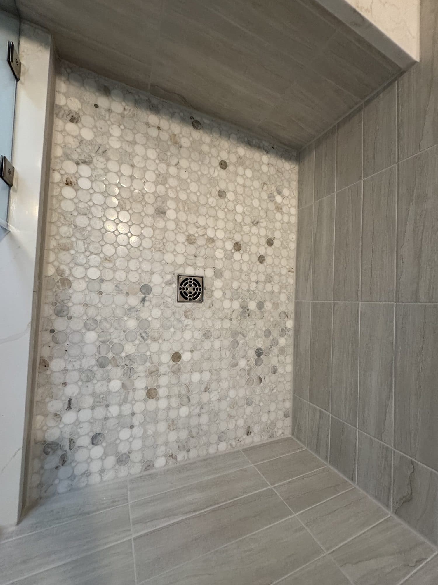 Circle marble mosaic shower floor with square drain in a Matthews, NC bathroom remodel