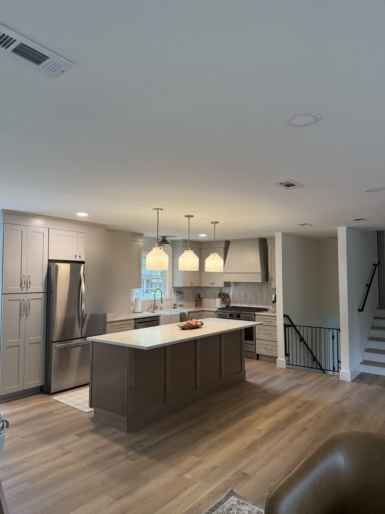 Floor-to-ceiling pantry cabinets, island and custom range hood in a SouthPark, Charlotte kitchen remodel
