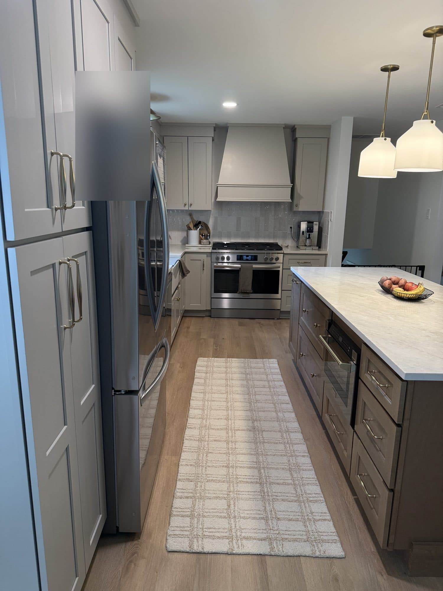 Custom painted range hood, handmade-look tile backsplash and island with microwave drawer in a SouthPark, Charlotte kitchen