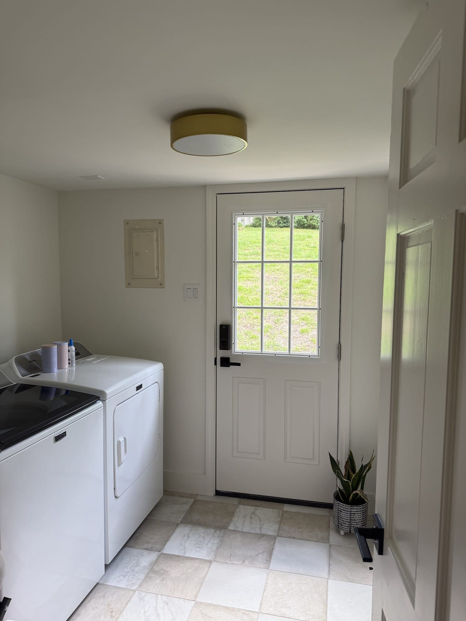 Laundry room with checkerboard tile floor and new exterior door in a SouthPark, Charlotte whole-home remodel