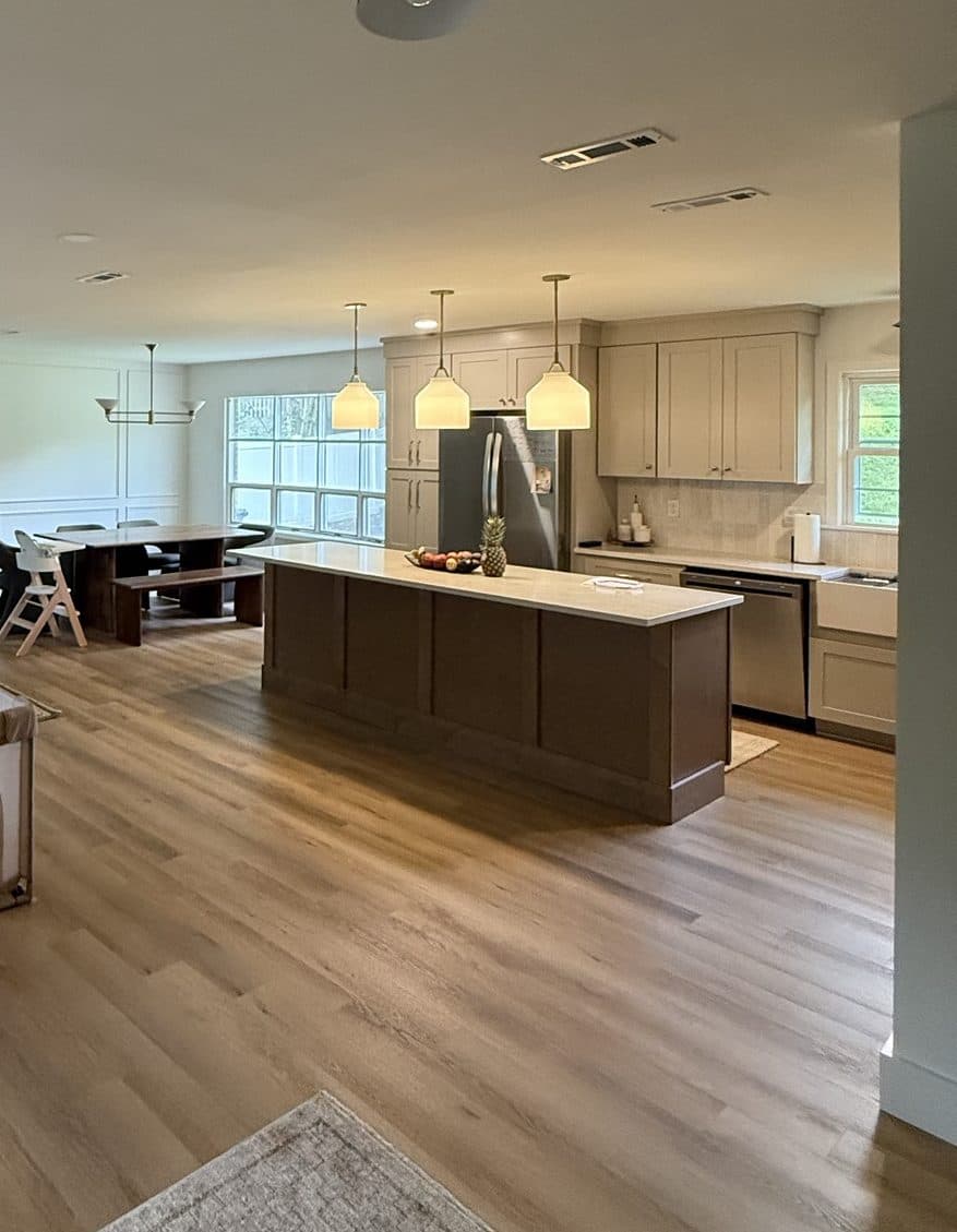 Whole-home remodel in SouthPark, Charlotte: walls removed to create one open kitchen, dining and living space with LVP floors