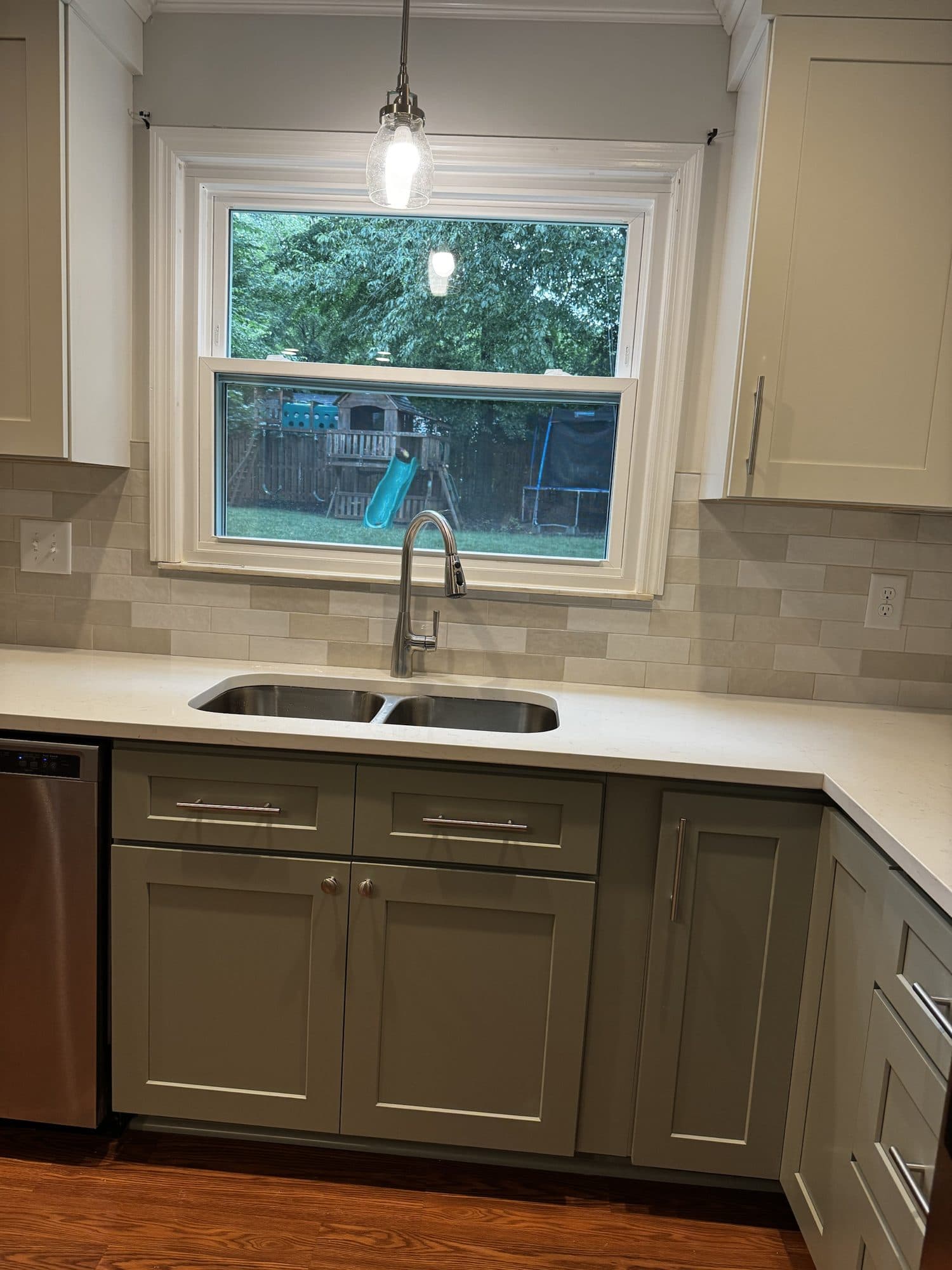Undermount double sink under a window with pendant light and quartz countertops in a Stonehaven, Charlotte kitchen remodel