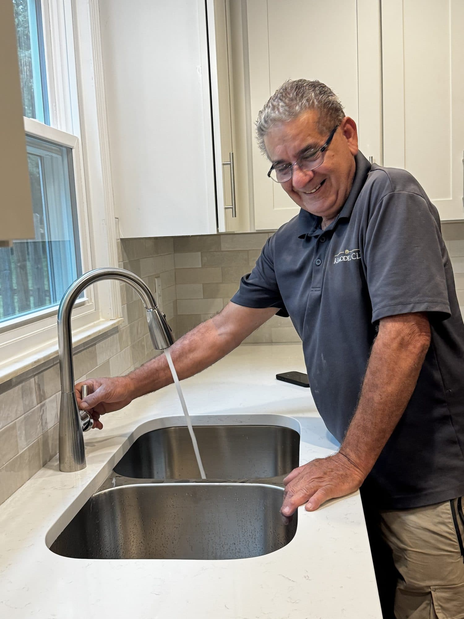 Richard Guadalupe of Remodel CLT testing a newly installed kitchen faucet in Charlotte NC