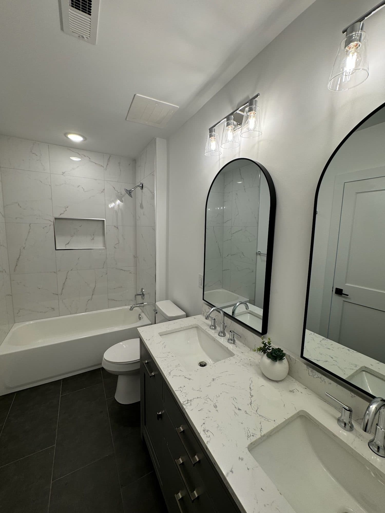 Marble-look porcelain tub surround with niche and charcoal vanity at The Arches townhomes, Charlotte NC