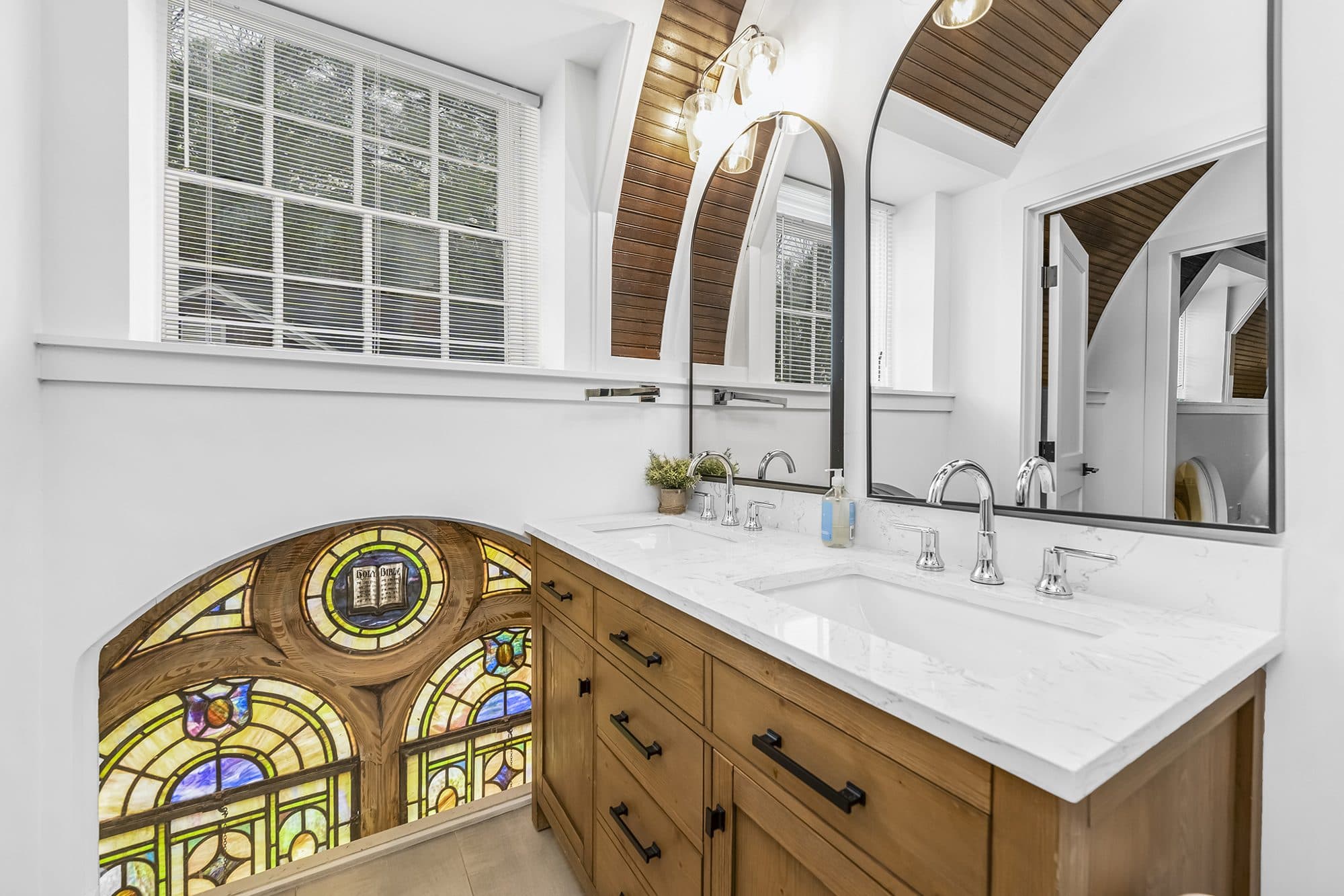 Bathroom with original stained glass and arched wood ceiling at The Arches church conversion in Wesley Heights, Charlotte