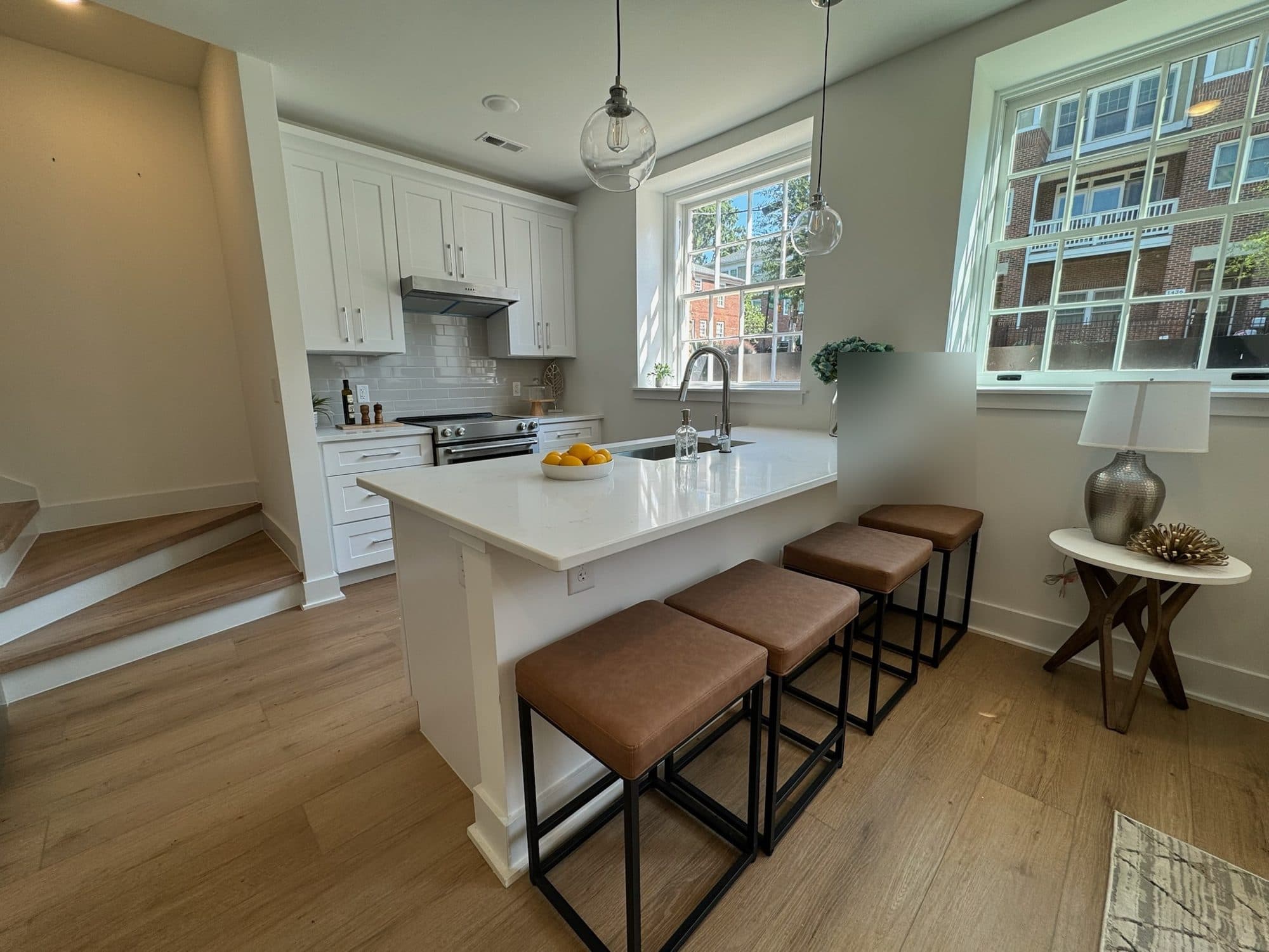 Kitchen peninsula with seating, globe pendants and LVP floors at The Arches townhomes, Wesley Heights, Charlotte