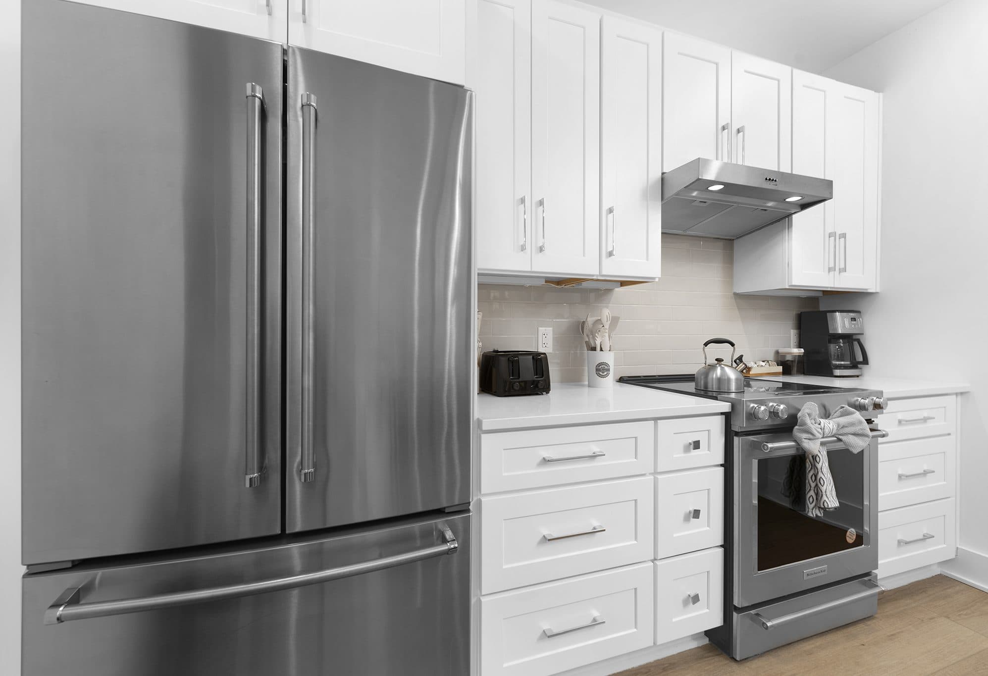 White shaker kitchen with quartz counters and subway tile backsplash at The Arches townhomes, Charlotte NC