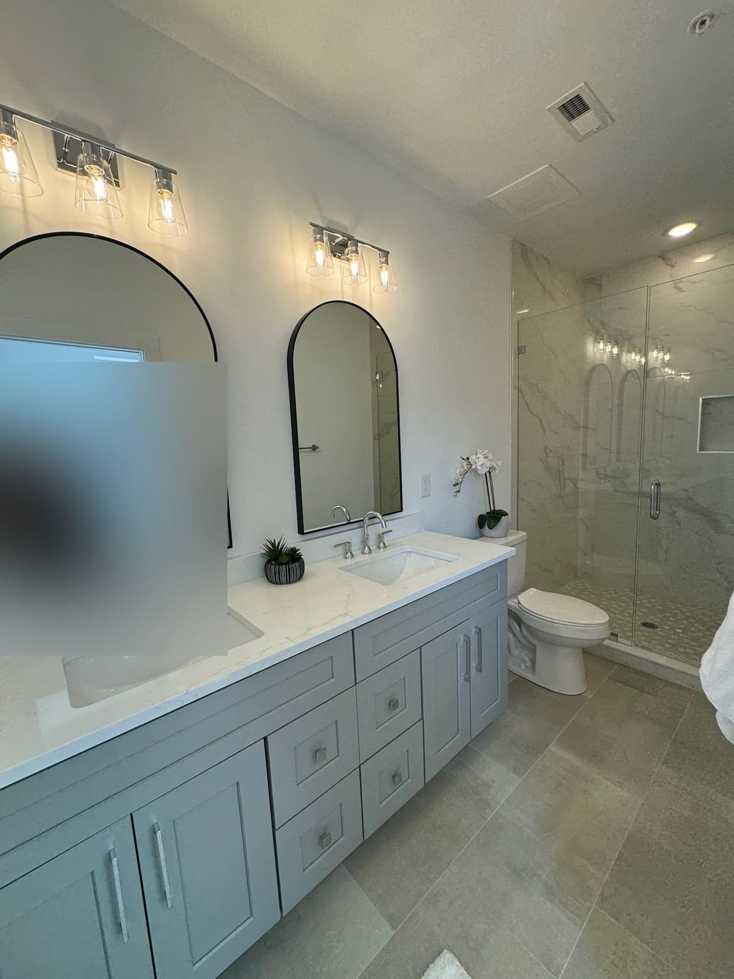 Primary bathroom with double vanity and marble-look walk-in shower at The Arches, Wesley Heights, Charlotte