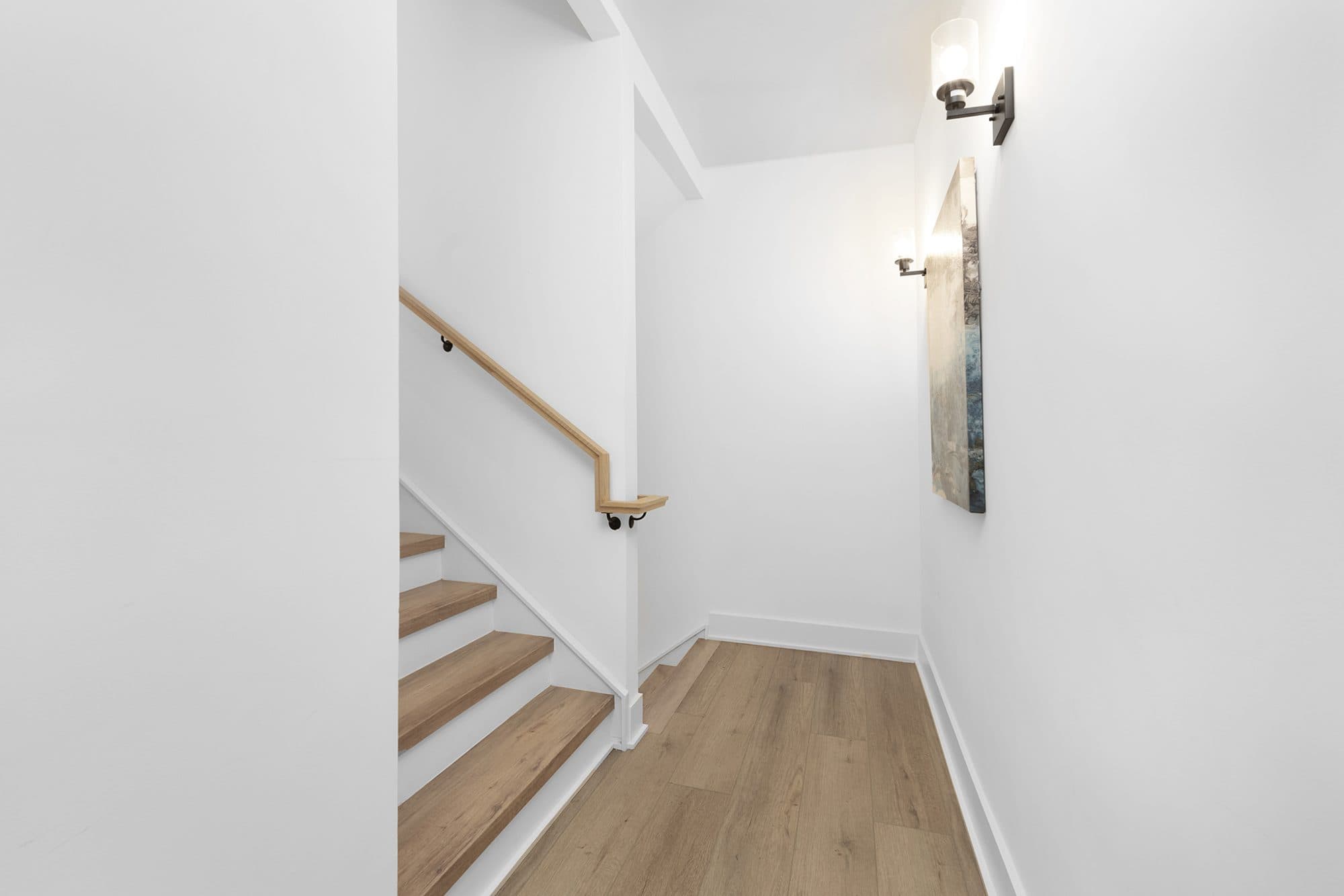 Stairway landing with LVP flooring and wall sconces at The Arches, Wesley Heights, Charlotte